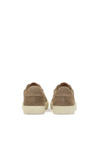 Beige Wildlederschuhe mit einem flachen Design und gepolsteter beige Sohle, die eine glatte Textur und eine abgerundete Ferse aufweisen.
