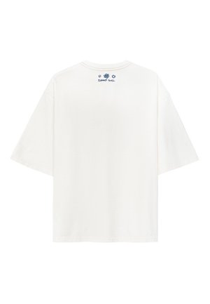 Biała, oversize'owa koszulka z krótkim rękawem, okrągłym dekoltem i małym niebieskim logo z tyłu, w pobliżu kołnierzyka. Materiał bawełniany, prosty wzór.