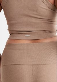 Brown ribbed crop top and high-waisted bottom, featuring a small silver logo detail. Soft texture with a fitted design.