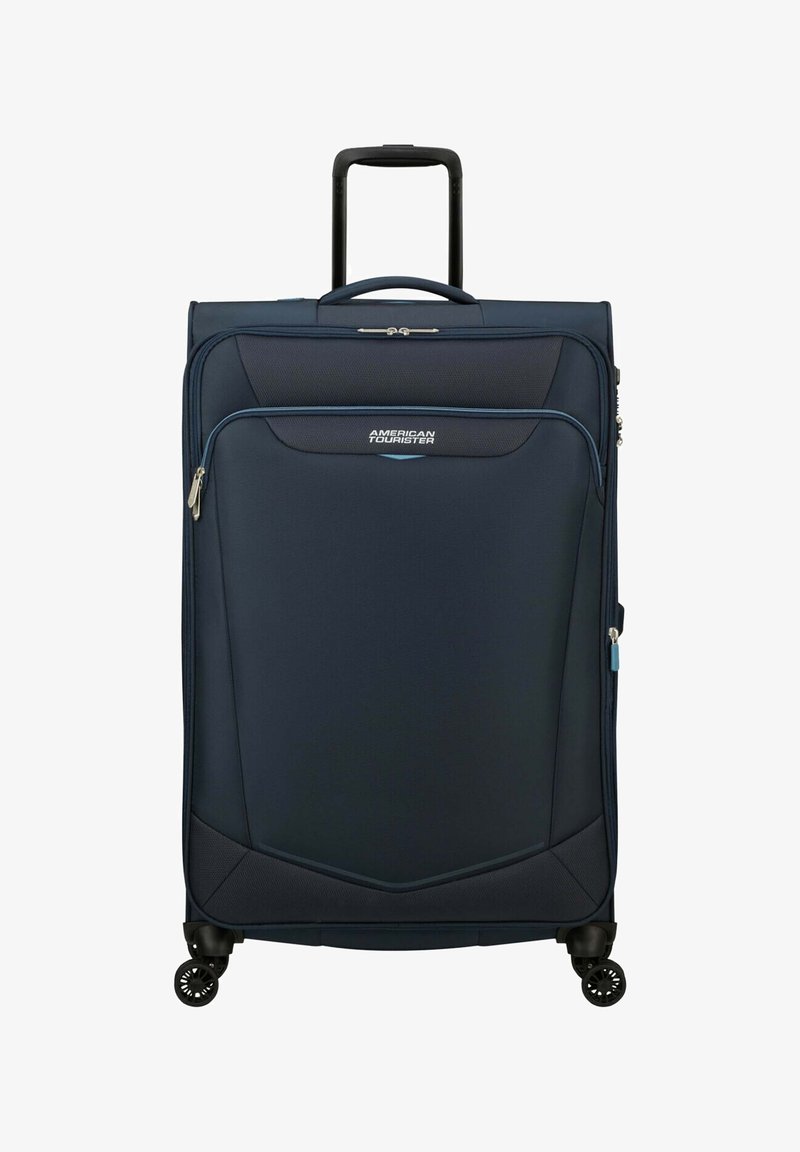 Valigia blu navy con finitura testurizzata, tasca frontale con zip, doppie maniglie di trasporto, manico retrattile e quattro ruote multidirezionali.