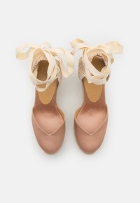 Espadrillas di raso rosa con punta arrotondata e tacco intrecciato. Presentano nastri di raso crema per legare alla caviglia e suole piatte.