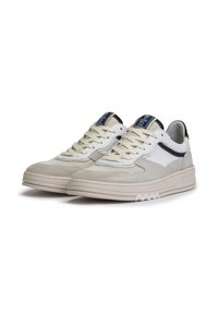 Sneakers bianchi e grigi con una tomaia in suede texturizzato e rete, colletto imbottito e suola spessa e rigata con accenti a zigzag.