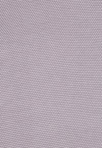 Muestra de tela texturizada en color lavanda claro, con un patrón tejido uniforme, superficie ligeramente elevada y tacto suave.