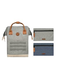 Grauer Stoffrucksack mit braunen Lederelementen und einem kleinen Logo. Enthält zwei Reißverschlusstaschen in Grau und Blau mit kontrastierenden Texturen.