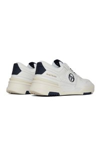 White sneaker with navy accents, featuring a textured upper, padded collar, and logo details. Thick, cream-colored sole with black tread.