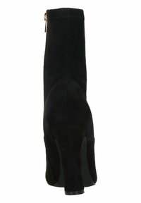 Czarna zamszowa botka na kostkę z wysokim obcasem, dopasowanym krojem, tylnym zamkiem błyskawicznym i gładką fakturą. Lekko zaokrąglony czubek i zwężająca się sylwetka.