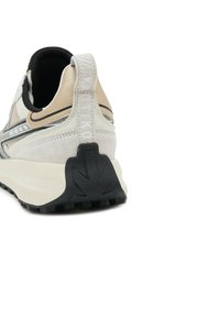 Sneaker met een witte en beige suède bovenkant, zwarte accenten en een gestructureerde zwarte rubberen zool. Voorzien van een achterste lijst met merknaam.