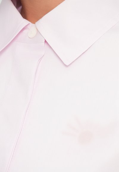 Ροζ ανοιχτό πουκάμισο με δομημένο γιακά, με κλείσιμο με κουμπιά και διακριτικό σκιασμένο μοτίβο που θυμίζει αντηλιακή ακτίνα στο ύφασμα.