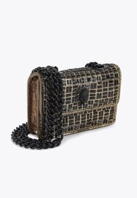 Petit sac à main noir et doré à motifs, avec une surface texturée, doté d'une chaîne noire et d'un fermoir en forme de tête de lion sur le rabat avant.