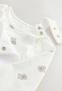 Weißer Baby-Body mit grauem Teddy-Bär-Druck, Druckknöpfe an der Schulter, weicher Stoff, lange Ärmel und runder Ausschnitt.