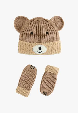 Knitinė kepurė ir pirštinės, rudos spalvos su meškos ausimis ir veidu. Kepurė turi šviesiai rudą briauną; pirštinės yra su raukšlėta tekstūra ir juodais nagų akcentais.