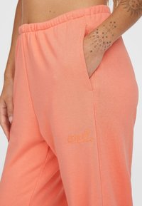 Koraalkleurige sweatpants met een elastische tailleband, zijzakken en een geborduurd "O'Neill" logo in bijpassend garen op het been. Zachte stoftextuur.
