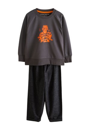 Grå sweatshirt med orange "IN THE MIX" grafik på ryggen, kombineret med ternede pyjamasbukser med høj talje. Sat mod en neutral baggrund.