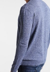 Blauer melierter Strickpullover mit gerippten Bündchen und Saum, mit Rundhalsausschnitt und glatter Textur, von hinten gezeigt.