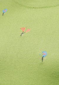 Tissu tricoté vert clair avec de petites fleurs brodées orange et bleues dispersées sur la surface.