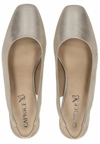 Metalické stříbrné slingback boty se čtveratou špičkou, hladkým povrchem, minimálním švem a polstrovaným béžovým interiérem. Viditelné logo značky.