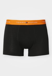 Boxers noirs avec une ceinture orange vif arborant le texte blanc "Tommy Hilfiger" et un petit logo de drapeau rouge, blanc et bleu centré.