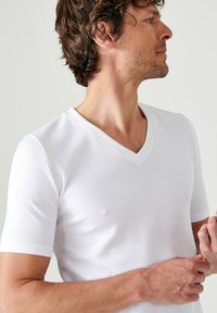 Witte T-shirt met korte mouwen en V-hals, gemaakt van zachte katoen, met een aansluitend ontwerp en een gladde textuur. Geen zichtbare patronen of accenten.