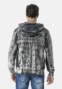 Zwart en grijs hoodie met een gestructureerd ontwerp en gedetailleerde afbeeldingen op de achterkant, voorzien van een kangaroo-zak. Het materiaal oogt zacht en duurzaam.