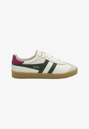 Zapatilla blanca con rayas verdes y una pestaña trasera morada. Presenta una suela de goma texturizada y el logo de Gola en dorado en el costado.