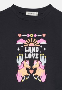 Schwarzes Kurzarm-T-Shirt mit einem bunten Grafikdesign, das zwei Einhörner, Kakteen, Herzen und den Text "LAND OF LOVE" in fetten Buchstaben zeigt.