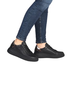 Black leather sneakers with a sleek design, featuring a textured heel and a raised sole for added height. Metal accents enhance the look.