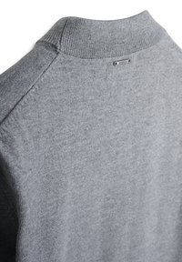 Maglione grigio lavorato a maglia con colletto a coste e tessuto texturizzato. L'etichetta indica il nome del marchio, posizionata sul retro della scollatura.