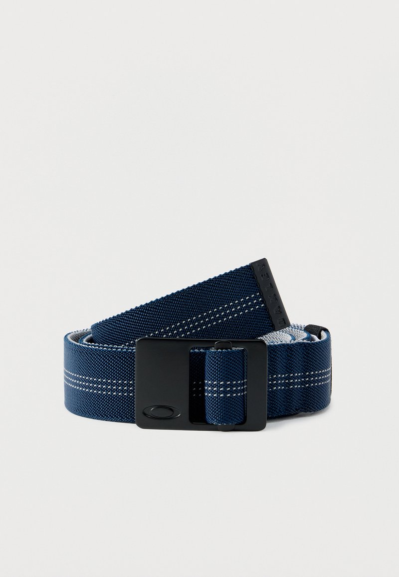 Ζώνη από ύφασμα σε ναυτικό μπλε με λευκές ραμμένες ρίγες, μαύρη ορθογώνια αγκράφα και μαύρο λαστιχένιο άκρο με λογότυπο, τυλιγμένη σε λευκό φόντο.