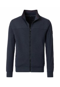 Marinekleurige zip-up jack met hoge kraag, gestructureerde stof en rode accenten langs de kraag. Beschikt over ribgebreide manchetten en onderkant.