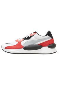 Sneaker featuring a combination of white mesh, red suede, and grey textile, with black accents and large cushioned sole. Classic lace-up design.