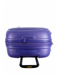 Valise rigide violette avec une finition texturée, double zip, poignée rétractable et un cadenas à combinaison approuvé par la TSA.