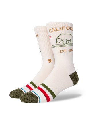 Knee-high socks with a cream base, green bear graphic, "CALIFORNIA" text, and colored stripes in red, green, and blue at the toe and cuff.