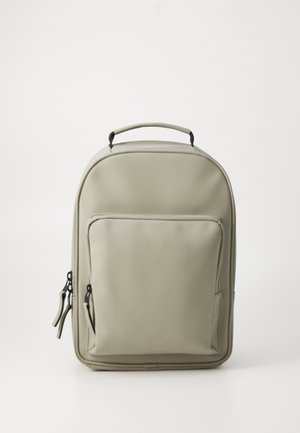 Light green backpack with a smooth texture, rectangular shape, top handle, and front zip pocket. Features black zipper pulls and brand logo.