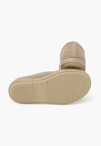 Sandalo in tessuto beige con tomaia intrecciata, cinturino elastico al tallone e suola in gomma testurizzata. Dettagli del marchio e della misura impressi sulla suola.