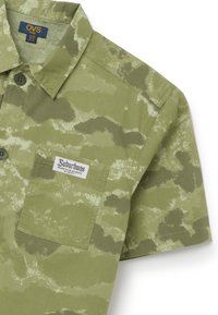 Olijfgroen overhemd met korte mouwen, voorzien van een subtiel camouflagepatroon, een borstzak en een "OVS" label op de kraag.