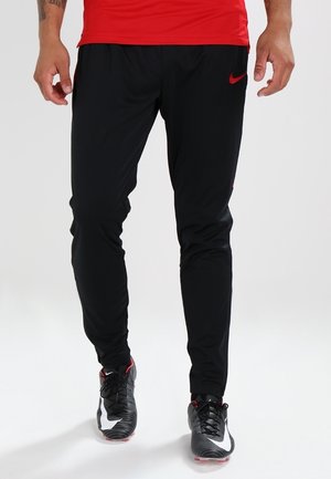 Sorte atletikbukser lavet af let, elastisk materiale med en tætsiddende pasform, der har et rødt Nike-logo på siden.