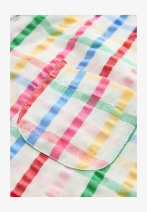 Tessuto di cotone multicolore con motivo a quadri in rosso, blu, verde, giallo e bianco. Presenta una piccola tasca con bordi curvi.