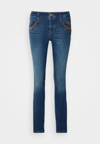 Jean en denim bleu foncé à la coupe slim, présentant un léger effet délavé, des poches avant avec des surpiqûres décoratives marron, et une fermeture par bouton.
