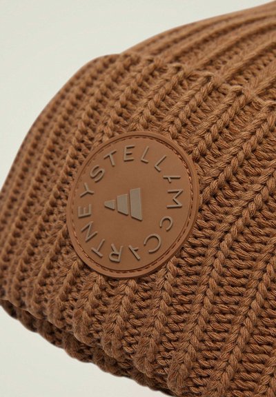Bonnet en tricot marron avec un motif texturé ; présente un patch logo en caoutchouc marron rond avec un texte en relief.