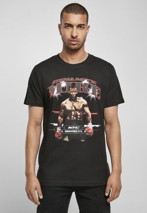 Camiseta de algodón negra con un estampado gráfico de un boxeador con guantes de box rojo. El texto incluye "DYNAMITE MOORE" y "NYC BROOKLYN."