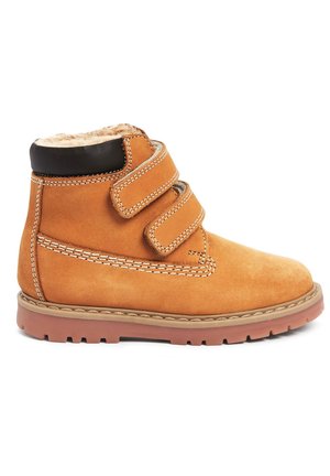 Tanfarbene Wildleder-Ankle Boots mit zwei verstellbaren Klettverschlüssen, weichem Innenfutter, brauner Gummisohle und kontrastierenden Nähdetails.