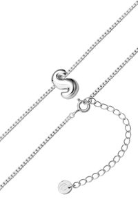 Sudraba ķēdes aproce ar stilizētu S formas aizdari, saites dizainu un regulējamu ķēdi ar apaļu tagu.