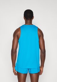 Μπλε αθλητική φανέλα χωρίς μανίκια από ελαφρύ ύφασμα, με άνετη εφαρμογή, συνδυασμένη με αντίστοιχο σορτς.