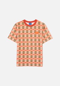 T-shirt à manches courtes avec un motif patchwork multicolore de fleurs et de carrés sur un fond clair, avec un col rond rouge.