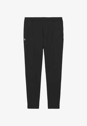 Zwarte broek met rechte pijpen, riemlussen en zijzakken, met een klein groen-wit krokodillenlogo op de linker dij.