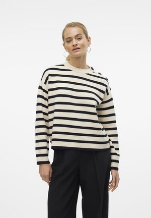 Sweater rayé crème et noir avec un col bateau, des épaules tombantes, des poignets côtelés et un détail de bouton sur une épaule. Matière tricot doux.
