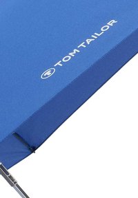 Blue rectangular umbrella with silver hardware; features the "Tom Tailor" logo in white. Smooth texture, designed for outdoor use.