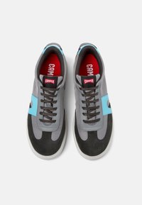 Grå sneakers med blå detaljer, övre del i mocka och textil, rund tåkappa, snördesign och röd innersula med "CAMPER"-logotyp.