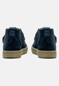 Tengerészkék velúr bokacsizmák barna gumitalppal, lapos sarkú, oldalán pántokkal és látható varrási részletekkel.