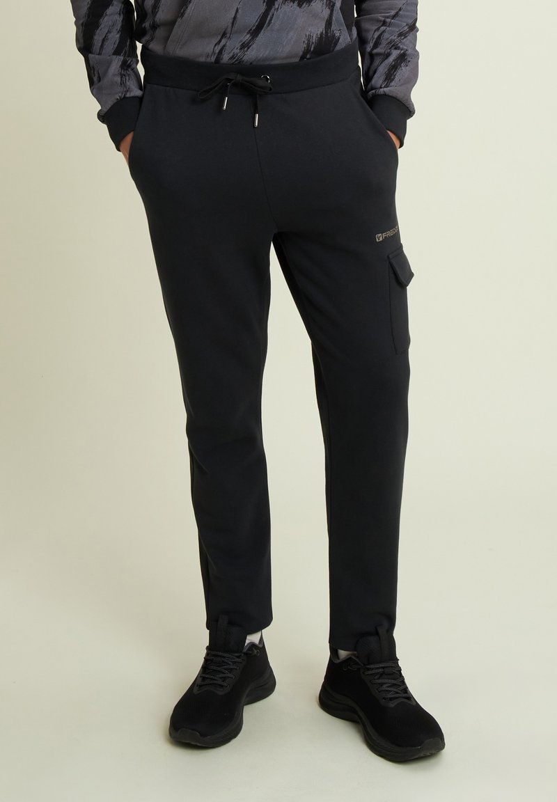 Pantalones de chándal negros, hechos de mezcla de algodón, con cintura elástica, cierre de cordón, bolsillo lateral tipo cargo y piernas ajustadas.